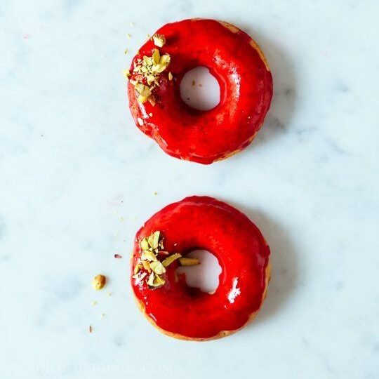 3 donuts in a line with red icing and sprinkles of nut